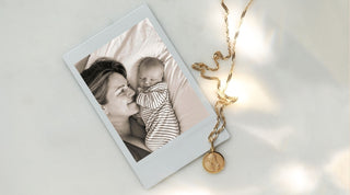 Polaroid of Carrie and her baby next to a solid gold mother and child pendant on chain