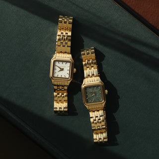 Gold watch with white square watch face